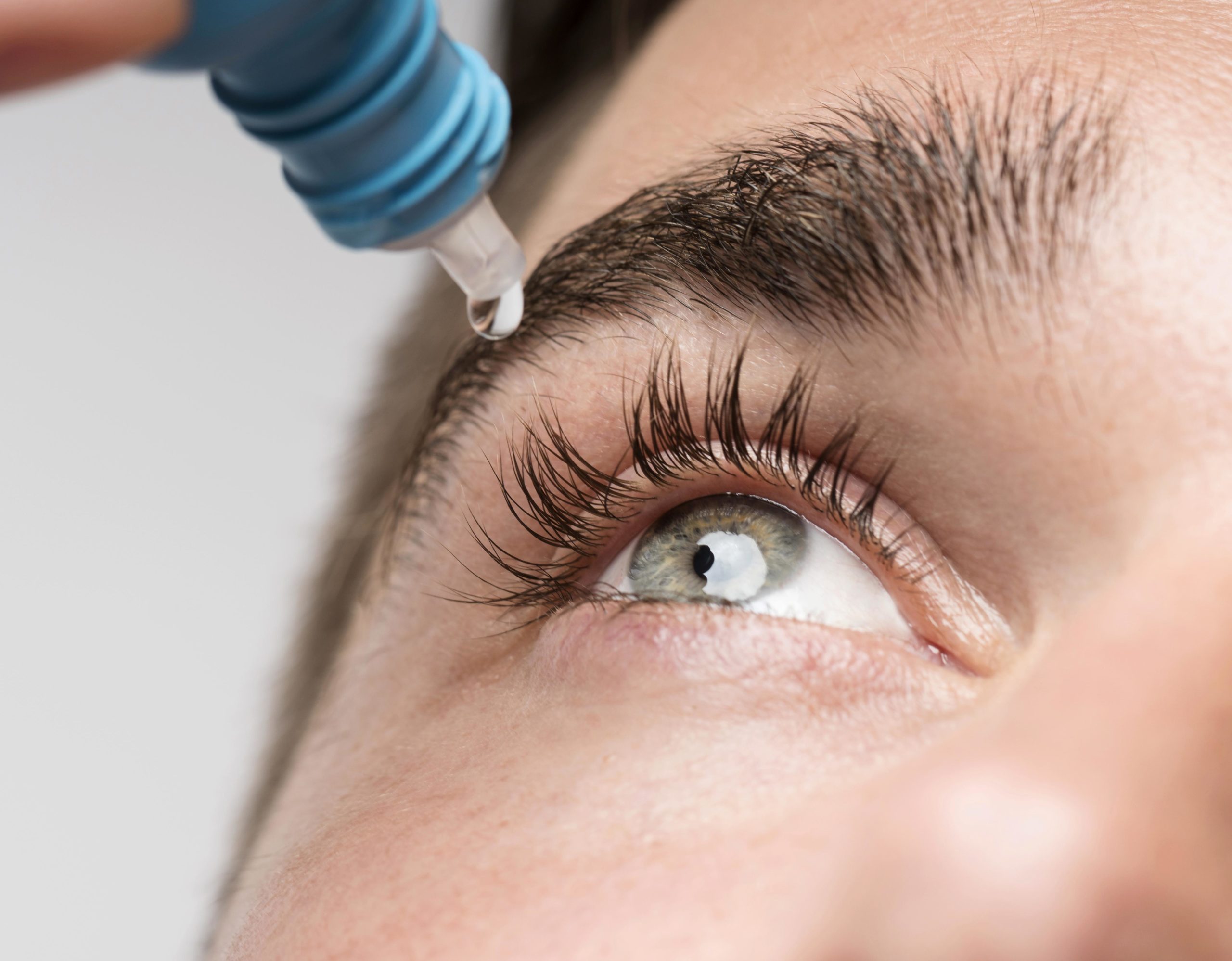 closeup of man using eye drops
