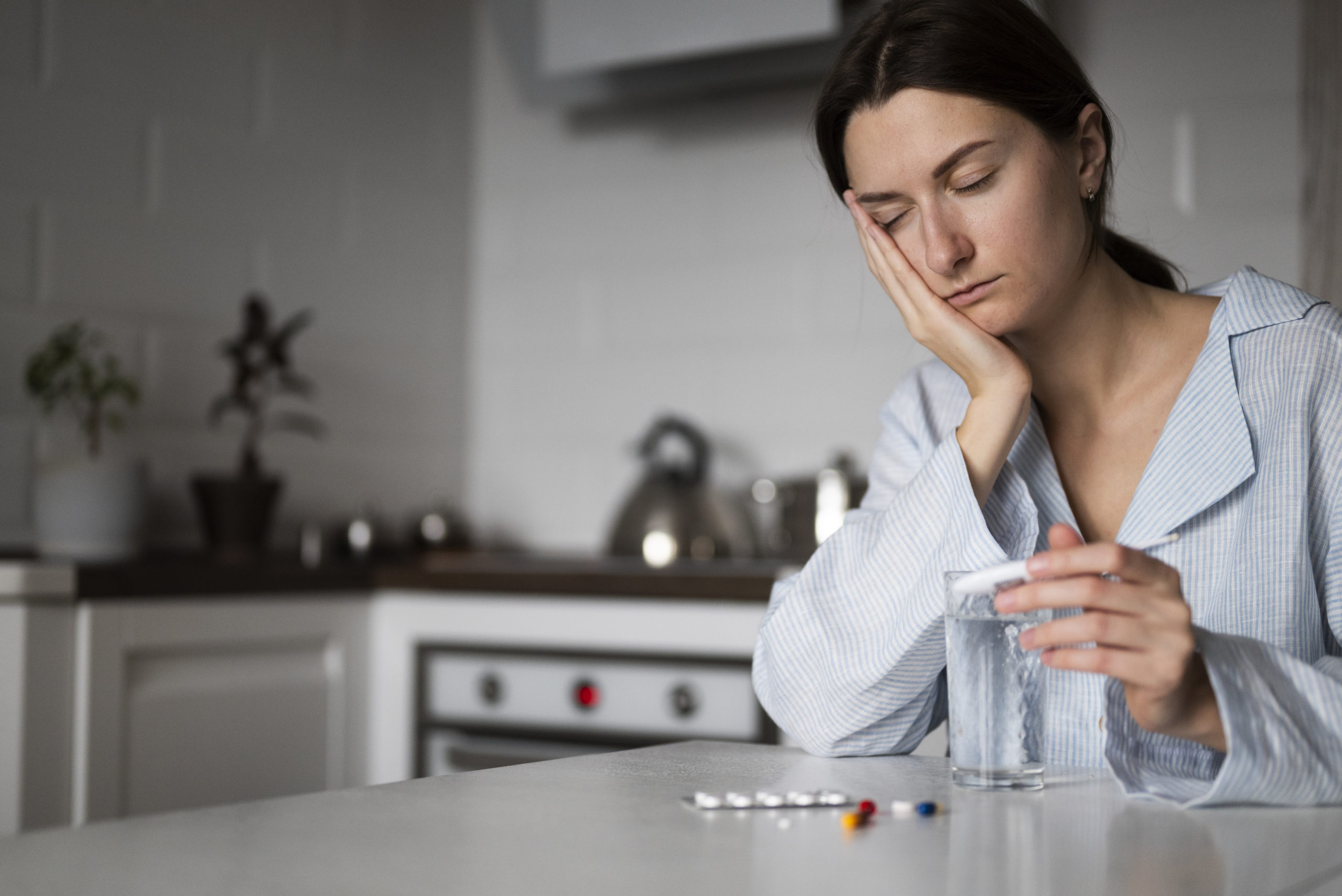 sick woman holding a thermometer