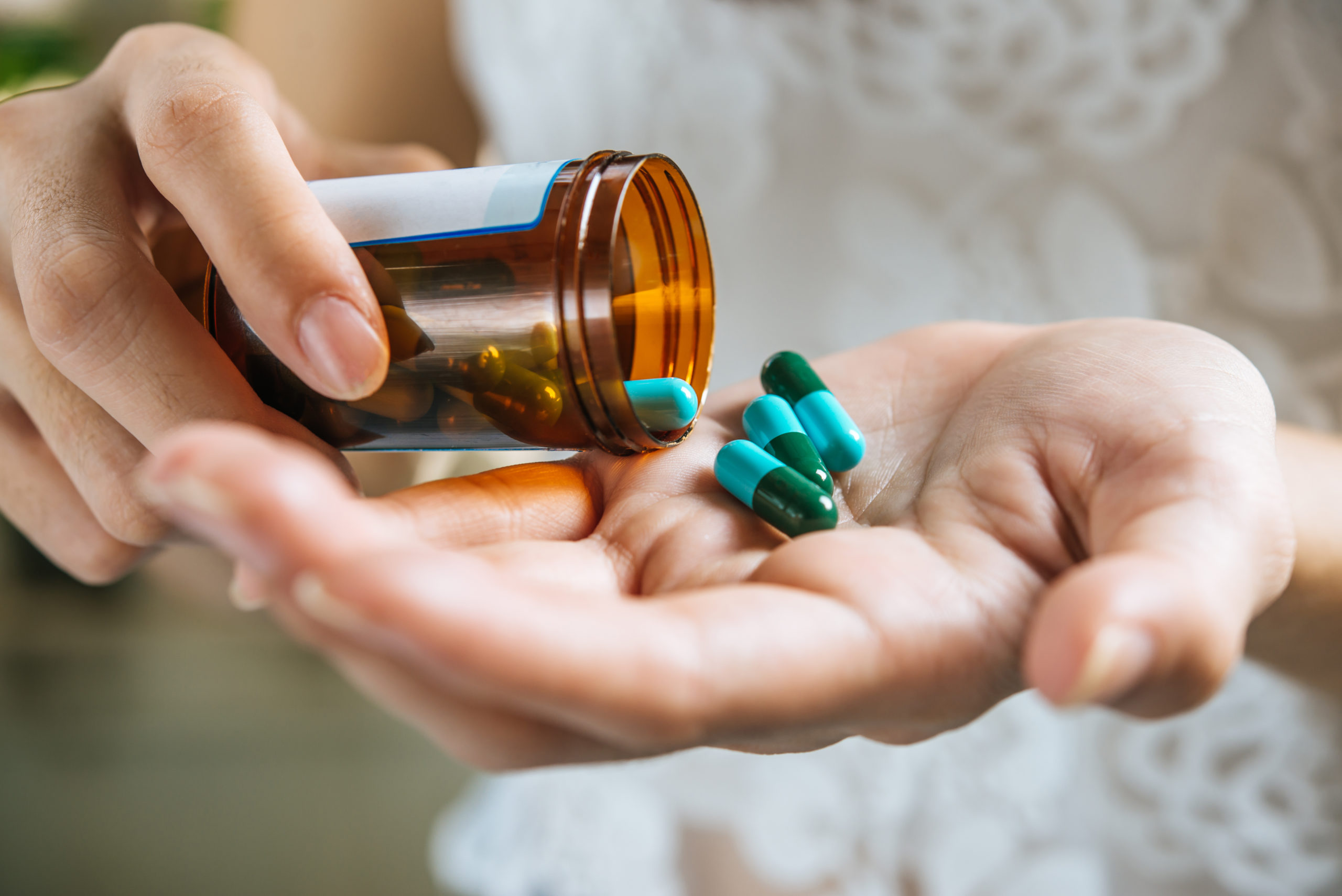woman pouring pills out of bottle